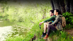 Couple gazing at nature together on river bank