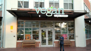 Picture of founder of Vegan Fine Foods standing in front of his storefront